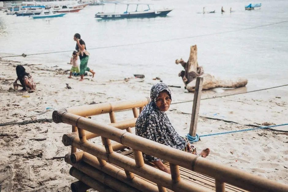Perempuan memakai pelembap wajah di teras rumah pesisir Pulau Sebatik dengan latar laut pagi